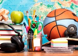 Przybory szkolne obok słuchawek i piłki do koszykówki