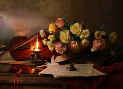 Róże obok skrzypiec i płonącej świecy
