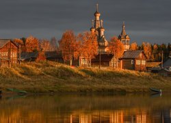 Rozświetlone słońcem domy i cerkiew nad rzeką