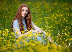 Rudowłosa kobieta na łące żółtych kwiatów