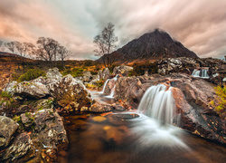 Skalny wodospad wpadający do jesiennej rzeki w szkockich górach