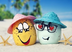 Śmieszne jajka w kapeluszach na morskiej plaży