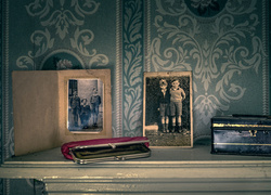 Stare podniszczone fotografie i portfel na komodzie