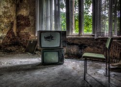Stare telewizory w zaniedbanym pomieszczeniu