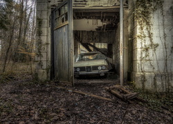 Stary samochód w walącym się garażu