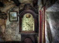 Stary stojący zegar w zaniedbanym pomieszczeniu