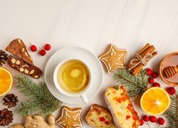 Świąteczne ciasteczka i gałązki obok filiżanki z herbatą