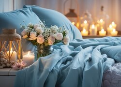 Świece i lampion z bukietem róż obok łóżka