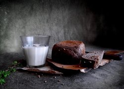 Szklanka mleka obok chleba położonego na desce