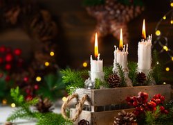 Trzy palące się świeczki w dekoracji świątecznej