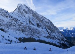 Turyści na rowerach we francuskich Alpach zimą