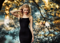 Uśmiechnięta blondynka w czarnej sukience