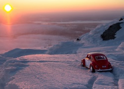Volkswagen zabawka na śniegu o zachodzie słońca