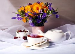 Wazonik z kwiatami obok filiżanki z herbatą
