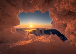 Widok z zaśnieżonej jaskini na wschód słońca