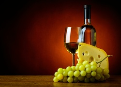 Wino w butelce i kieliszku oraz ser i winogrona