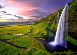 Wodospad Seljalandsfoss w Islandii spływa z klifu porośniętego roślinnością