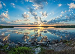 Jezioro Kiantajarvi, Wschód słońca, Kamienie, Brzeg, Niebo, Chmury, Odbicie, Gmina Suomussalmi, Finlandia