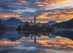 Słowenia, Jezioro Bled, Wyspa Blejski Otok, Kościół Zwiastowania Marii Panny, Góry, Alpy Julijskie, Zachód słońca, Chmury, Odbicie