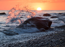 Wzburzone morskie fale uderzają o kamienie nad brzegiem morza