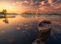 Zacumowana łódka w blasku zachodzącego słońca