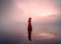 Zamyślona kobieta w zamglonym jeziorze
