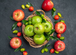 Zielone jabłka w koszyku i czerwone obok