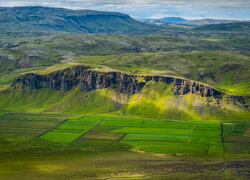 Zielone pola na tle wzgórz w Islandii
