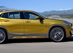 Żółte BMW X2 na górskiej drodze