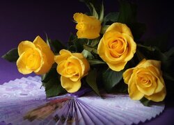 Żółte róże leżące na wachlarzu