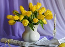 Żółte tulipany w wazonie ze świecą i nutami
