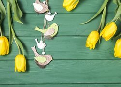 Żółte tulipany z drewnianymi ptaszkami