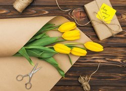 Żółte tulipany na papierze obok prezentu