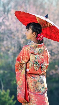 Azjatka w kimono pod czerwoną parasolką