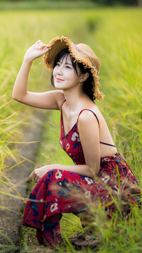 Azjatka w słomkowym kapeluszu na polu