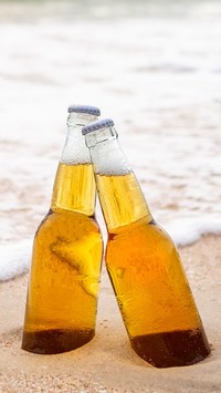Butelki piwa w piasku