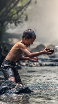 Chłopiec bawiący się w rzece