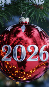 Czerwona bombka z datą 2026 na gałązce świerkowej