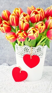 Czerwone serca na doniczce z tulipanami