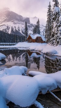 Dom pod ośnieżonym lasem nad jeziorem Emerald Lake