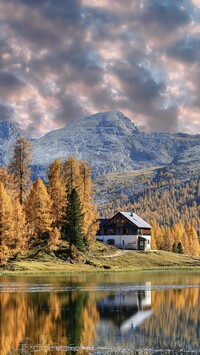 Dom wśród pożółkłych modrzewi nad jeziorem Lago Federa