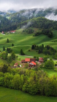 Domy w dolinie i zamglone góry
