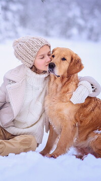 Dziewczynka i golden retriever na śniegu