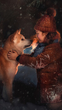 Dziewczynka i pies akita inu na śniegu
