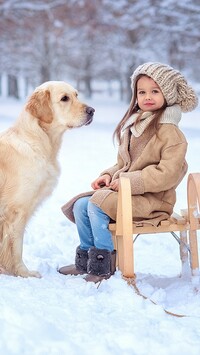 Dziewczynka na sankach i golden retriever