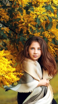 Dziewczynka w szalu pod kwitnącą akacją