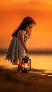 Dziewczynka z lampionem na plaży