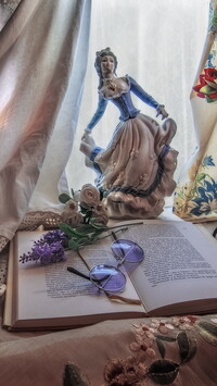Figurka kobiety obok otwartej książki