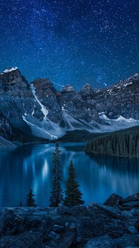 Gwiazdy nocą nad jeziorem w górach