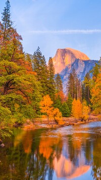 Jesienne drzewa nad rzeką Merced i góra Half Dome w tle